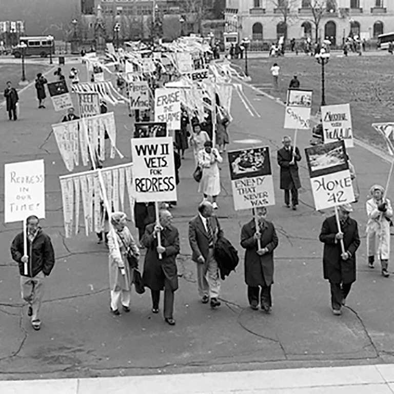 Participants holding placards at the Japanese Canadian Redress Rally on Parliament Hill in Ottawa, 1988