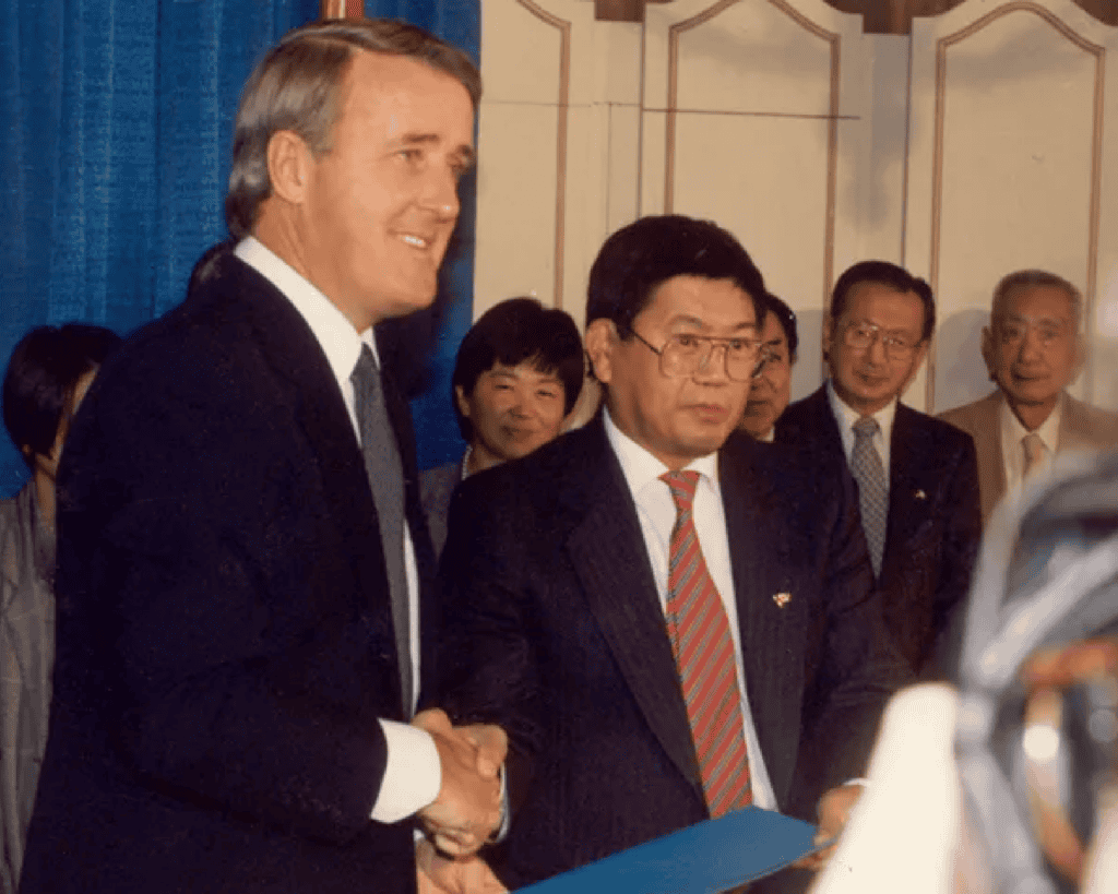Art Miki shaking hands with Brian Mulroney following the historic 1988 Redress Agreement